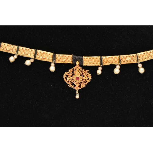 82 - AN INDIAN NECKLACE, designed with a central fancy floral and beaded pendant with central ruby suspen... 