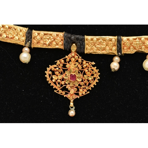 82 - AN INDIAN NECKLACE, designed with a central fancy floral and beaded pendant with central ruby suspen... 