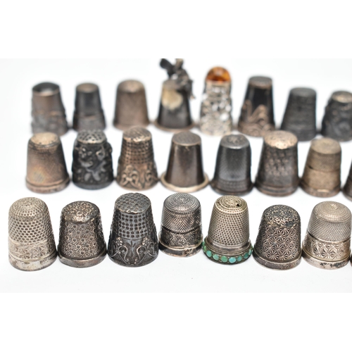 141 - A BAG OF WHITE METAL THIMBLES, various designs and patterns, some set with semi-precious stone termi... 