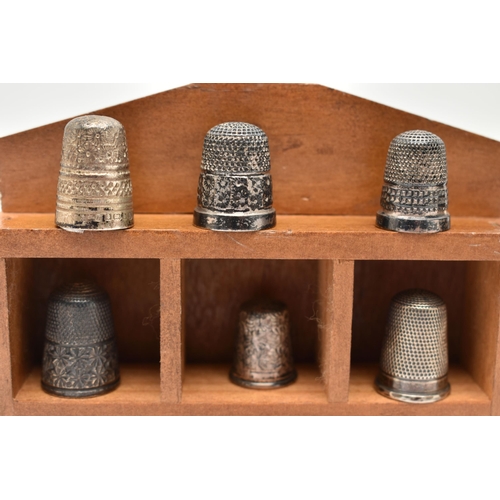 142 - A SELECTION OF SILVER THIMBLES AND TWO DISPLAY UNITS, to include twenty-two thimbles, various design... 