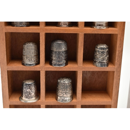 142 - A SELECTION OF SILVER THIMBLES AND TWO DISPLAY UNITS, to include twenty-two thimbles, various design... 