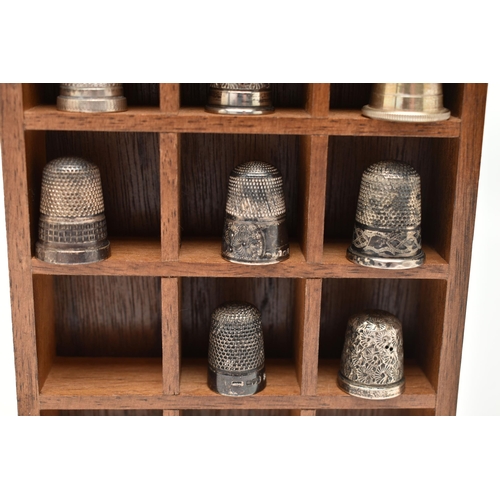 142 - A SELECTION OF SILVER THIMBLES AND TWO DISPLAY UNITS, to include twenty-two thimbles, various design... 