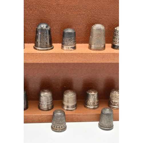 143 - A SELECTION OF SILVER THIMBLES AND TWO DISPLAY SHELVES, to include twenty-two thimbles, various desi... 