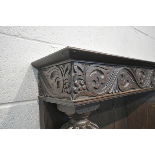 1208 - A LARGE EARLY 20TH CENTURY OAK FIRE SURROUND, with scrolled and foliate carvings, bulbous turned sup... 