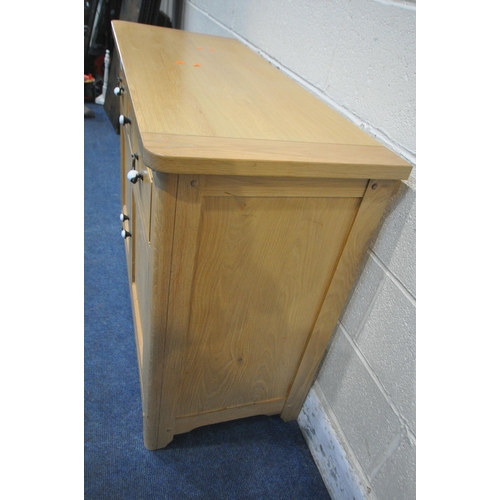 1263 - A MODERN LIGHT OAK SIDEBOARD, fitted with three drawers, over double cupboard doors, width 115cm x d... 