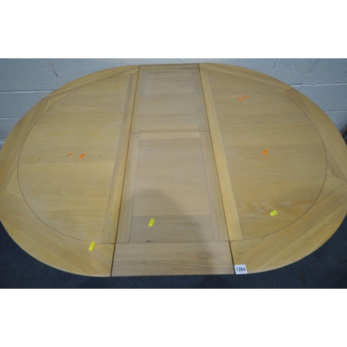 1264 - A MODERN LIGHT OAK CIRCULAR EXTENDING PEDESTAL DINING TABLE, with a single fold out leaf, open width... 