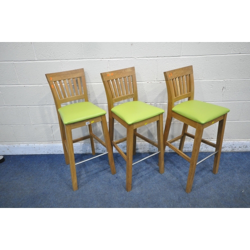 1288 - A SET OF THREE OAK BAR STOOLS, with a tubular metal footrest and lime green upholstery, width 37cm x... 