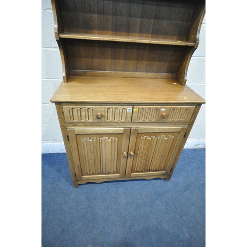 1294 - A 20TH CENTURY OAK DRESSER, the arched top with a two tier plate rack, atop a base with two drawers ... 