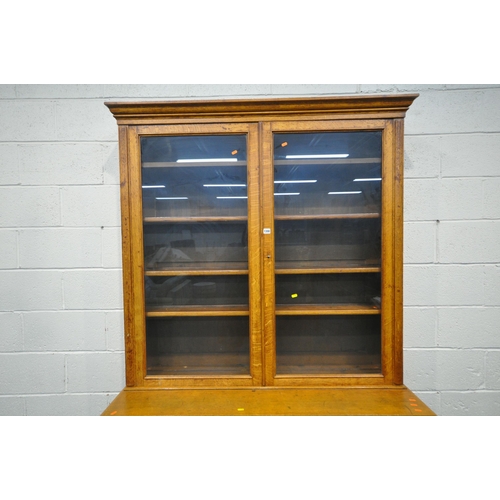 1300 - AN EARLY 20TH CENTURY OAK BOOKCASE, the double glass doors enclosing four adjustable shelves, atop a... 