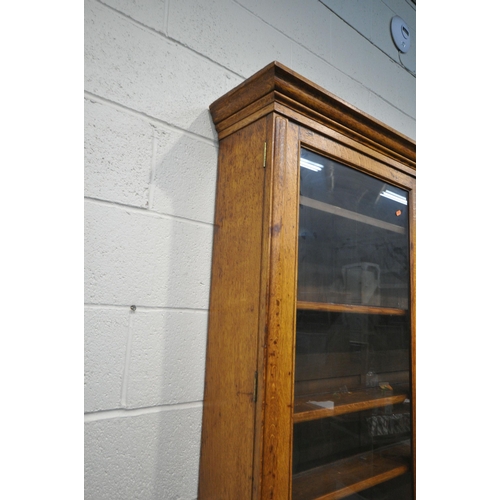 1300 - AN EARLY 20TH CENTURY OAK BOOKCASE, the double glass doors enclosing four adjustable shelves, atop a... 