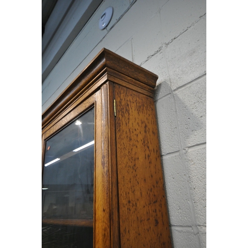 1300 - AN EARLY 20TH CENTURY OAK BOOKCASE, the double glass doors enclosing four adjustable shelves, atop a... 