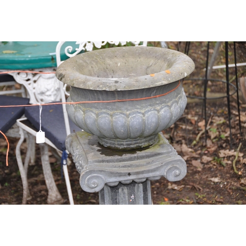 1018 - A PAIR OF CAMPAGNA GARDEN URNS, possibly basalt or slate like material, with both sat on similar col... 