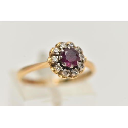 13 - AN 18CT GOLD RUBY AND DIAMOND CLUSTER RING, of a circular form, centrally set with a circular cut ru... 