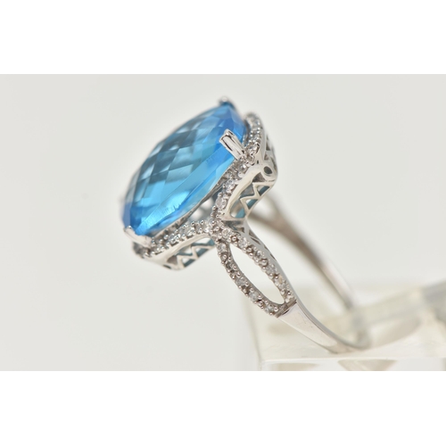 42 - A 'KALLATI' TOPAZ AND DIAMOND DRESS RING, a large rectangular cut blue topaz, approximate length 14m... 