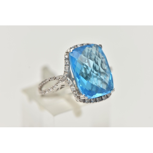 42 - A 'KALLATI' TOPAZ AND DIAMOND DRESS RING, a large rectangular cut blue topaz, approximate length 14m... 