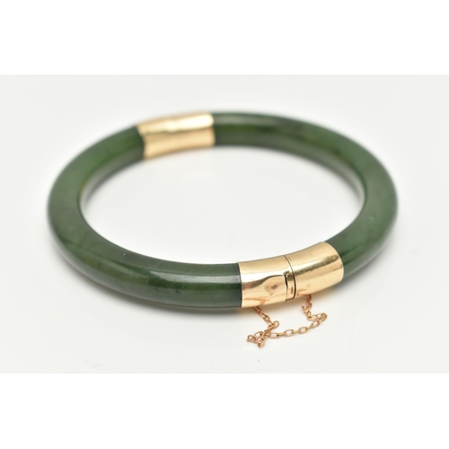 9 - A NEPHRITE JADE BANGLE, with fittings to the hinge and clasp, safety chain attached, clasp stamped 1... 