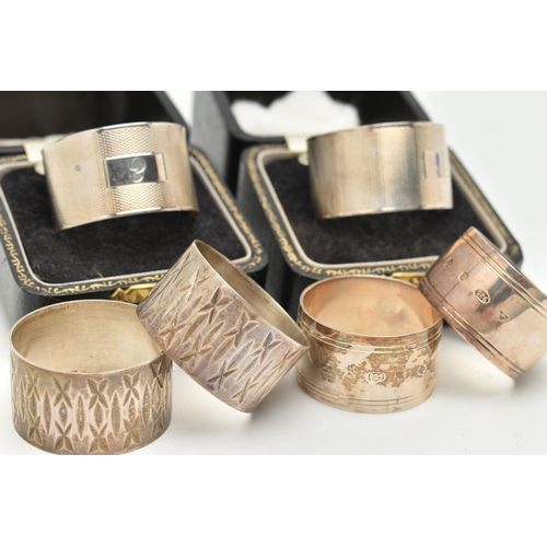 117 - THREE SETS OF SILVER NAPKIN RINGS, to include two boxed engine turned pattern rings, engraved initia... 