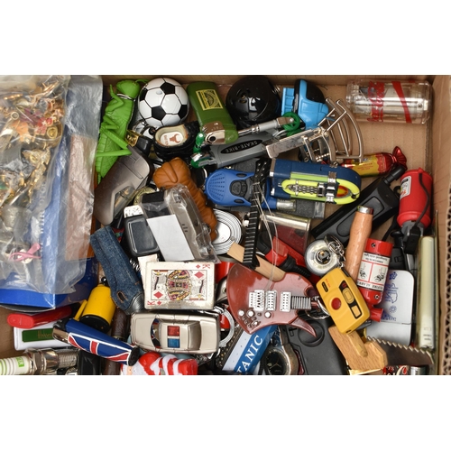 129 - A BOX OF ASSORTED ITEMS, to include various novelty lighters, in forms such as a phone, chocolate, s... 