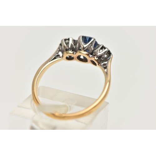 90 - A YELLOW METAL SAPPHIRE AND DIAMOND RING, centering on an oval cut, deep blue sapphire, flanked by i... 