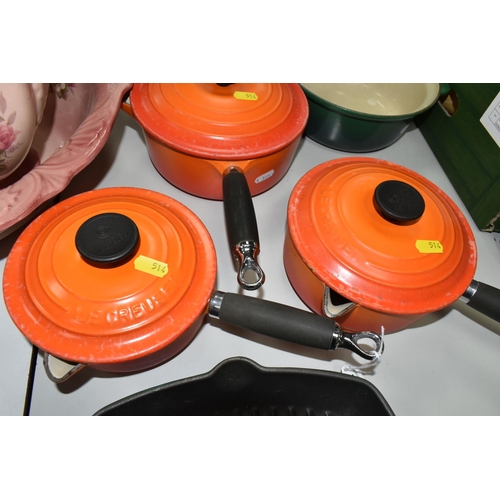 514 - LE CREUSET KITCHEN WARE IN GREEN AND ORANGE, comprising a set of three orange saucepans with lids in... 