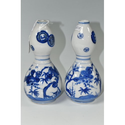 582 - A PAIR OF JAPANESE DOUBLE GOURD VASES, painted in blue with trees and foliage, unmarked, height appr... 