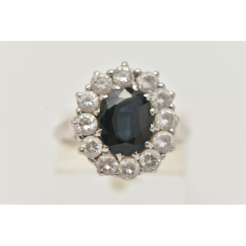 156 - A 9CT GOLD SAPPHIRE RING, a principally set oval cut sapphire, with a surround of circular cut cubic... 