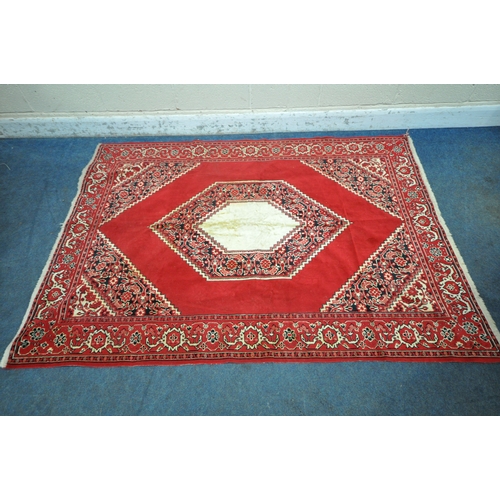 1199 - A RED GROUND SYNTHETIC SILK RUG, with central medallion, foliate designs and multi-strap border, 196... 