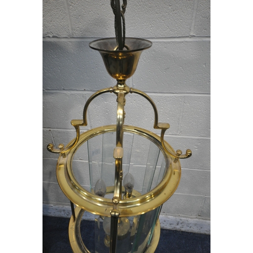 1220 - A 20TH CENTURY BRASS CYLINDRICAL HALL LANTERN, the glass panes encasing a four branch light fitting,... 