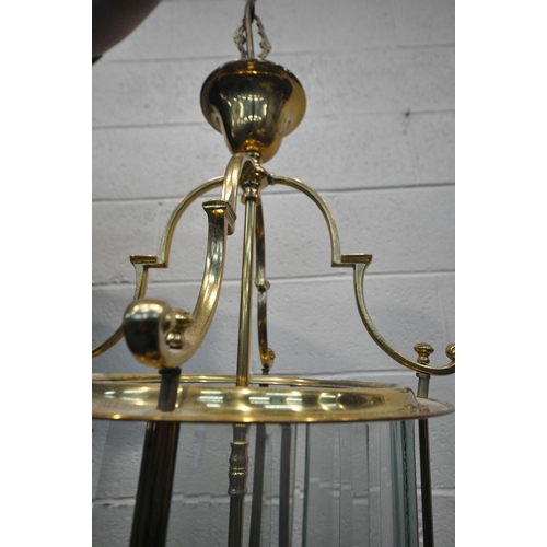 1220 - A 20TH CENTURY BRASS CYLINDRICAL HALL LANTERN, the glass panes encasing a four branch light fitting,... 