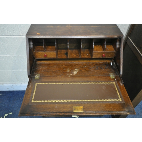 1259 - AN EARLY 2OTH CENTURY OAK BOOKCASE, the fall front door enclosing a fitted interior, above three dra... 