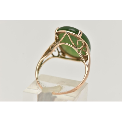 14 - A YELLOW METAL, NEPHRITE CABOCHON RING, of an oval form, nephrite measuring approximately length 18.... 