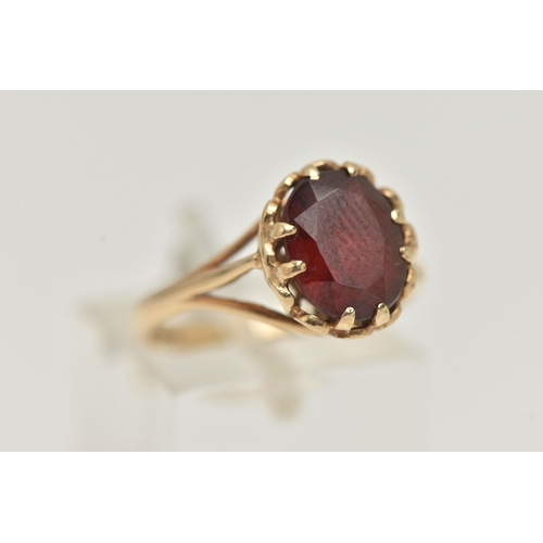 16 - A 9CT GOLD GARNET SET RING, oval cut garnet in a double four claw setting, measuring approximately 1... 