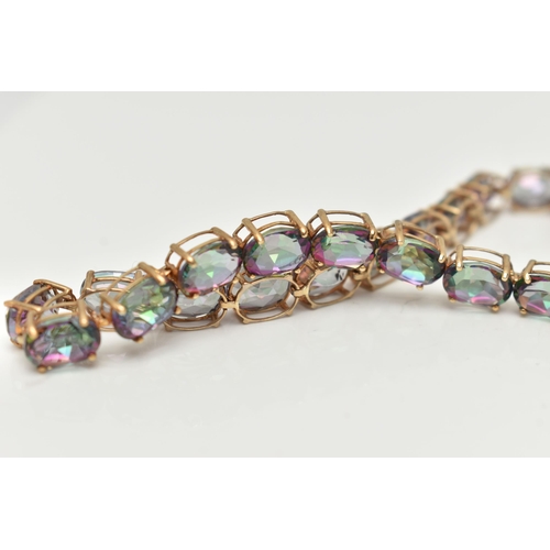 20 - A 9CT GOLD MYSTIC TOPAZ LINE BRACELET, designed as a series of twenty-two oval cut, mystic coated to... 