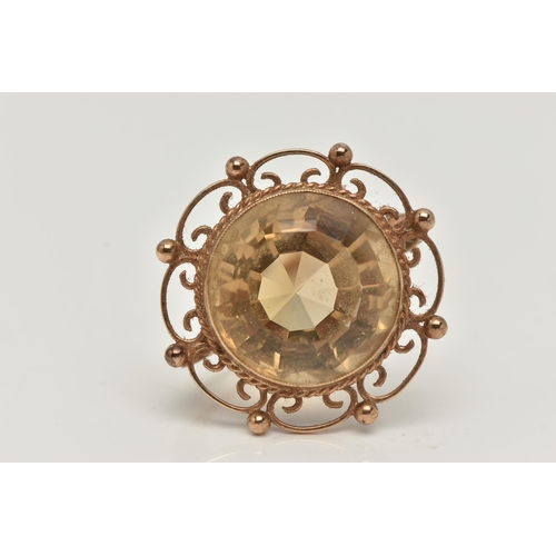 23 - A 9CT GOLD CITRINE BROOCH, of a circular form, set with a large circular cut citrine, milgrain colle... 