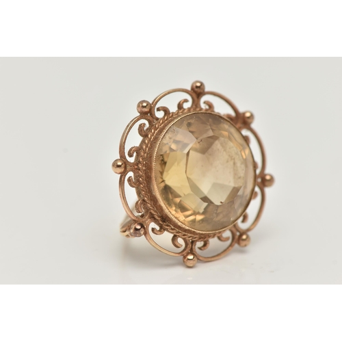 23 - A 9CT GOLD CITRINE BROOCH, of a circular form, set with a large circular cut citrine, milgrain colle... 