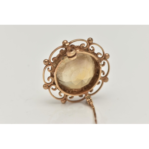 23 - A 9CT GOLD CITRINE BROOCH, of a circular form, set with a large circular cut citrine, milgrain colle... 