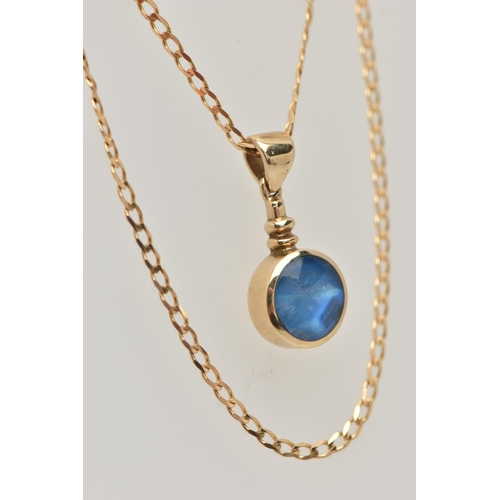 27 - A 9CT GOLD GEM SET PENDANT AND CHAIN, the circular pendant set with a blue sheen cabochon, possibly ... 