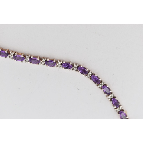 36 - A 9CT YELLOW AND WHITE GOLD AMETHYST AND DIAMOND BRACELET, designed as a series of twenty six oval s... 