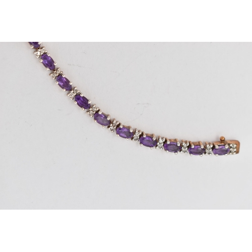 36 - A 9CT YELLOW AND WHITE GOLD AMETHYST AND DIAMOND BRACELET, designed as a series of twenty six oval s... 