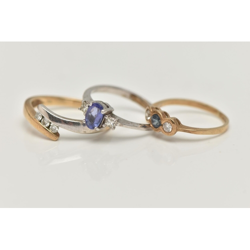 47 - THREE 9CT GOLD GEM SET RINGS, the first a three stone diamond ring in a bi colour bypass mount, hall... 