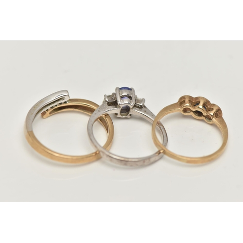 47 - THREE 9CT GOLD GEM SET RINGS, the first a three stone diamond ring in a bi colour bypass mount, hall... 