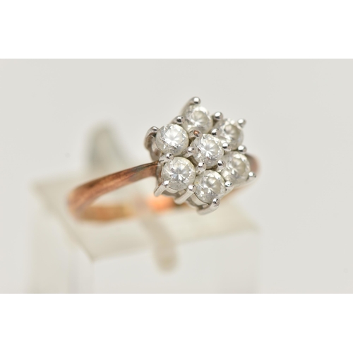 71 - A 9CT GOLD CLUSTER RING, seven circular cut cubic zirconia, prong set in white gold, leading onto a ... 