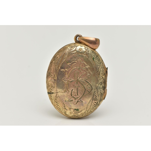 75 - A YELLOW METAL OVAL LOCKET, detailed with a floral and foliate pattern and engraved monogram, fitted... 