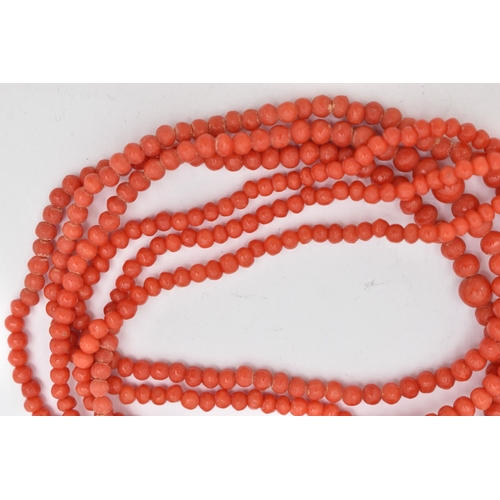 92 - A CORAL BEAD NECKLACE, triple strand of round polished graduated coral beads, fitted with a yellow m... 