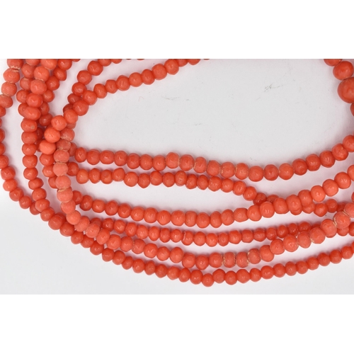 92 - A CORAL BEAD NECKLACE, triple strand of round polished graduated coral beads, fitted with a yellow m... 