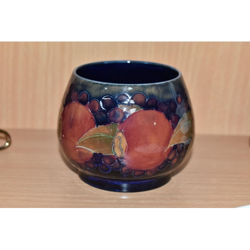 328 - A MOORCROFT POTTERY POMEGRANATE PATTERN SUGAR BOWL, the footed bowl tube lined with fruit on a dark ... 