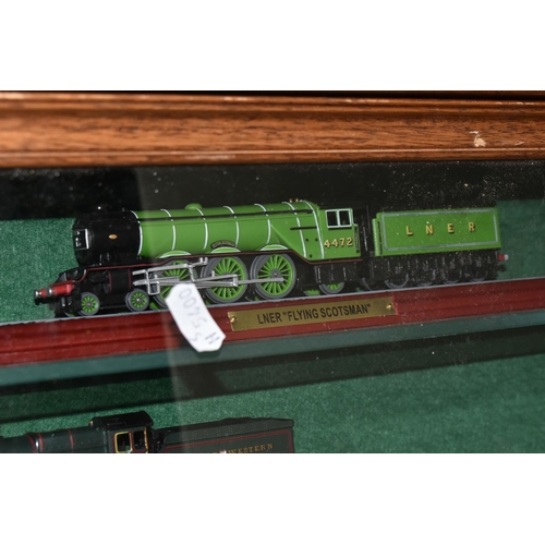 595 - A WALL MOUNTED WOODEN GLASS FRONTED SHELVING UNIT CONTAINING MODEL RAILWAY ITEMS, to include unboxed... 