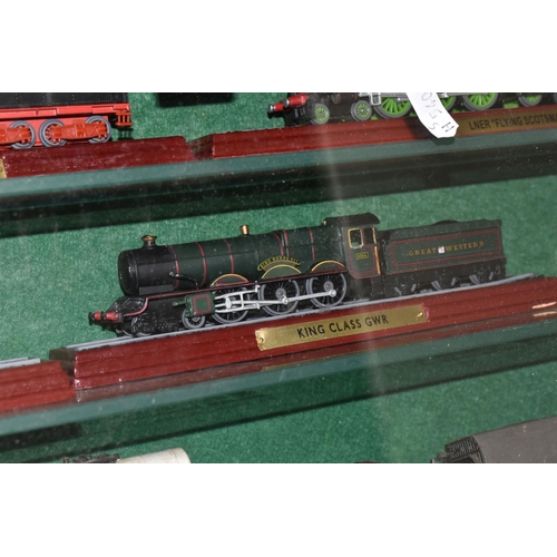 595 - A WALL MOUNTED WOODEN GLASS FRONTED SHELVING UNIT CONTAINING MODEL RAILWAY ITEMS, to include unboxed... 