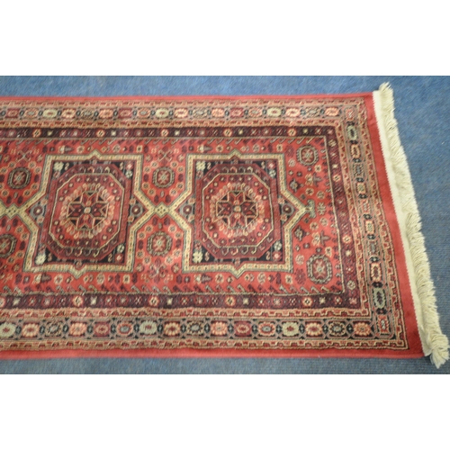 1266 - A LATE 20TH CENTURY SYNTHETIC RED PATTERNED CARPET RUNNER, 210cm (condition report: good)