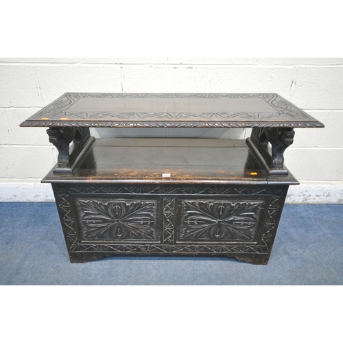 1308 - AN EARLY TO MID 20TH CENTURY DARK OAK MONKS BENCH, with lion armrests, flanking a hinged storage com... 